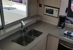 Modern kitchen in 2017 Leopard 48 yacht with sink, stove, microwave, and coffee maker.