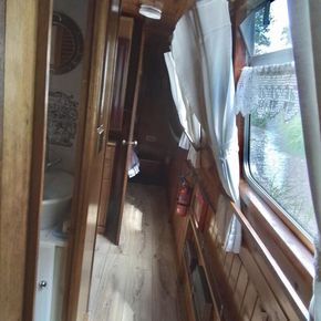 Looking down the length of the boat, from the kitchen, past the bathroom, middle bunks and into the rear cabin.  Cabin can be closed by wooden doors to either end of the cabin.