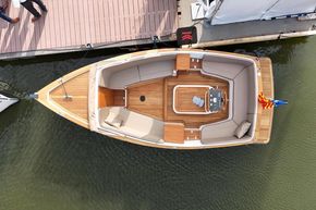Overhead view of 2026 Enkhuizensloep 680 Tender boat docked, featuring spacious seating and elegant design.