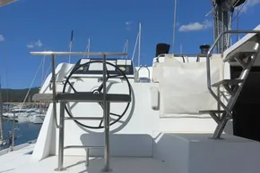 Helm of 2017 Lagoon 42 catamaran with clear blue sky and marina background.