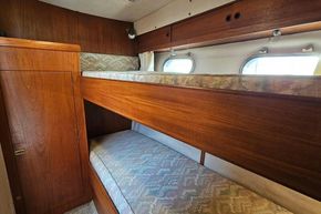 Cozy cabin with wooden bunk beds in 1989 Princess 35 Flybridge yacht.