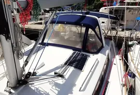 2017 Beneteau Oceanis 38 sailboat docked, featuring solar panels and blue canopy.