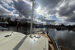 Linssen 360 AC yacht from 1994 on a serene river under a cloudy sky.