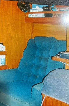 A chair is located forward on the starboard side of the Saloon. There is ample storage beneath.