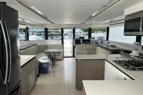 Luxurious interior of 2022 Leopard 53 Powercat yacht with modern kitchen and seating area.
