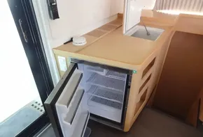 Open fridge and sink area in Lagoon 42 catamaran, 2020 model.