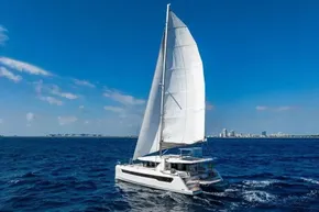 Sailing catamaran Leopard 46, 2025 model, cruising on open blue sea under clear skies.
