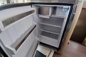 Open refrigerator inside 2024 Lagoon 42 yacht, showcasing spacious interior and shelving.