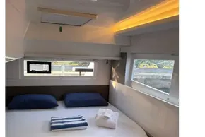 Luxurious cabin interior of 2022 Leopard 42 yacht with cozy bedding and natural light.