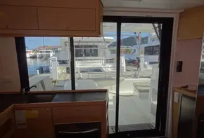 Interior view of 2020 Lagoon 42 catamaran kitchen and sliding door to deck.