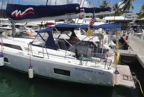 2020 Beneteau Oceanis 46.1 sailboat docked at marina with blue canopy and flags.