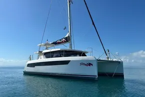 2022 Leopard 42 catamaran sailing on calm blue waters under clear skies.