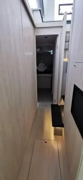 Narrow hallway inside a 2019 Leopard 51 Powercat yacht with light wood paneling.