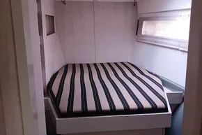 Interior of a 2017 Leopard 48 yacht featuring a cozy striped bed.