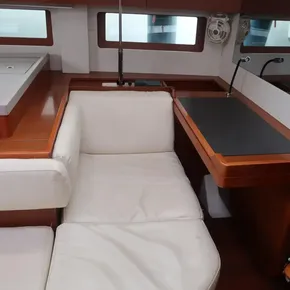 Interior of 2018 Beneteau Oceanis 51.1 yacht with white seating and wooden accents.