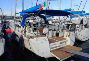 2019 Jeanneau Sun Odyssey 440 sailboat docked with blue canopy and Italian flag.