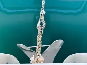 Anchor and rope on Leopard 40 catamaran, 2019, over calm turquoise water.