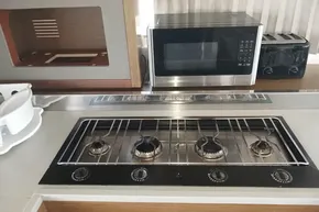 Modern kitchen in 2020 Lagoon 46 yacht with stove, microwave, and toaster.
