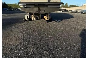 2025 Linssen 45 SL Sedan yacht on gravel lot, rear view under clear blue sky.