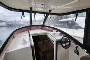 Interior view of 2023 Balt 818 Titanium boat cockpit with steering wheel and seating area.