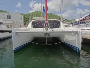 2021 Leopard 40 catamaran docked in marina, surrounded by lush green hills and blue sky.