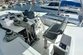 Helm station of 2022 Leopard 45 catamaran in marina, featuring ropes and navigation equipment.