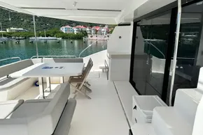 Leopard 53 Powercat 2022 yacht deck with seating and table, docked by scenic waterfront.