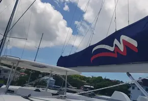 Leopard 48 sailboat from 2017 docked with sails up against a blue sky.