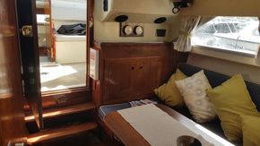 Interior of 1982 Fairline Mirage 29 Aft Cabin with cozy seating and wooden finishes.