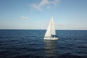 2013 Beneteau Oceanis 41 sailboat cruising on open sea under clear blue sky.