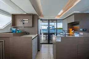 Modern interior of 2025 Leopard 40 Powercat yacht with ocean view through glass doors.