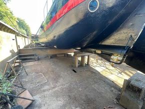Classic 1901 Dutch Barge in dry dock, showcasing hull and maintenance area.