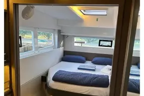 Interior of 2022 Leopard 42 yacht cabin with bed and windows.