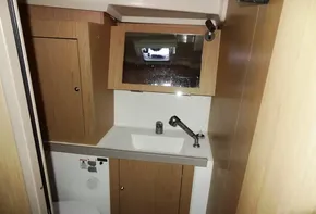 2017 Beneteau Oceanis 41 bathroom with sink, mirror, and wooden cabinetry.
