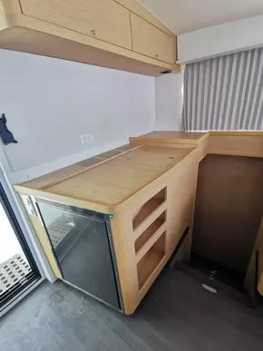 Interior of 2020 Lagoon 42 yacht with compact kitchen area and wooden cabinetry.