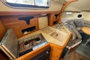 1991 Sealine 290 Ambassador yacht interior with kitchen, stove, sink, and cozy seating area.