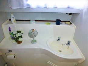 Bathroom sink area on a 1995 Aquafibre Bounty Boats 10/70 with toiletries and decor.