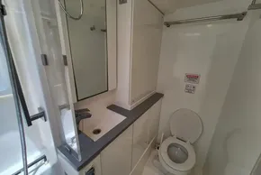 Modern bathroom in a 2021 Leopard 45 yacht, featuring a toilet, sink, and mirror.