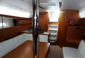 Interior of 2017 Jeanneau Sun Odyssey 389 sailboat with wooden furnishings and white seating.