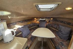 Interior of 1999 Wellcraft 2400 Martinique boat with cozy seating and table.