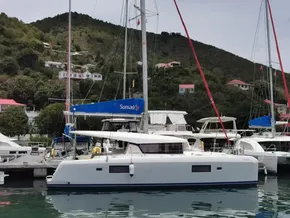 2020 Lagoon 42 catamaran docked in a scenic marina with hillside houses.