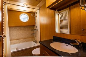 bathroom with bath/shower, flushing toilet and basin