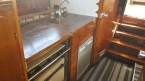 1982 Fairline Mirage 29 Aft Cabin kitchen with wood cabinetry and modern appliances.