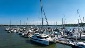 Marina with various sailboats, including a 2022 Leopard 50, under a clear blue sky.