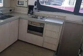 Modern kitchen in a 2017 Leopard 48 yacht with stove, oven, sink, and microwave.