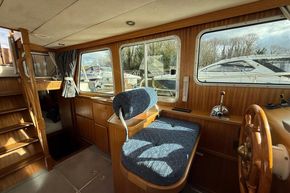 Interior of 1994 Linssen 360 AC boat with wooden helm and blue seating.