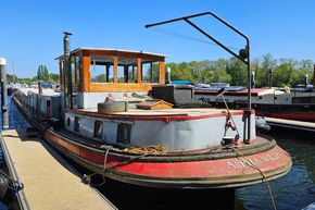 Luxemotor Dutch barge from 1926 docked at a marina under a clear blue sky.