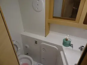 Compact bathroom in a 2020 Lagoon 42 catamaran with toilet, sink, and mirror.