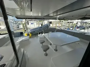 Spacious deck of 2020 Leopard 50 yacht with seating and table at marina.