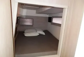 2020 Leopard 43 Powercat cabin with bed and pillows, featuring wooden interior and windows.